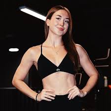 Woman in a black sports bra and leggings standing in a gym setting