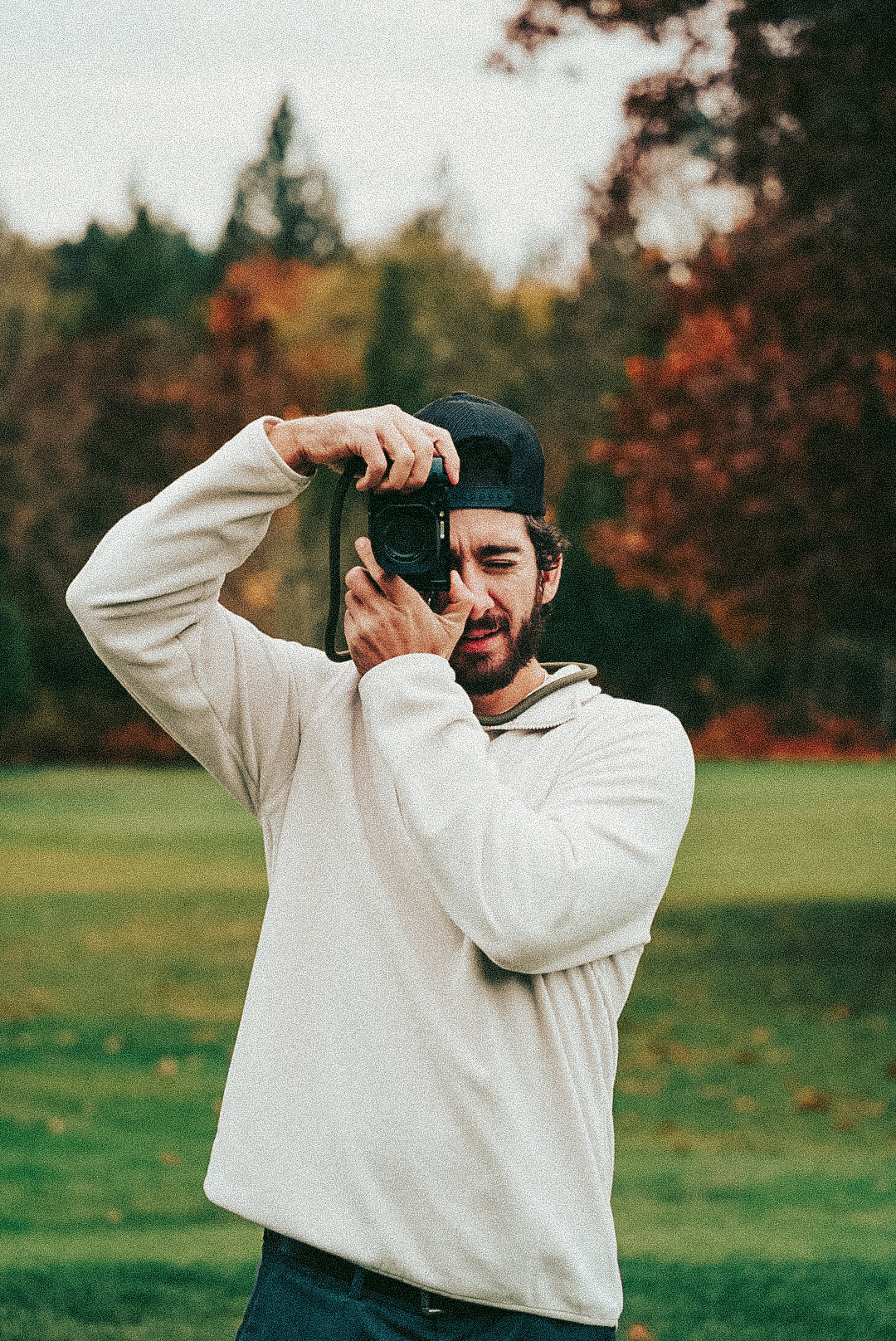 Man taking a photo with a camera in a park